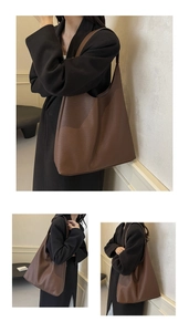 Detail view of large brown pebbled leather tote bag with elegant minimalist design