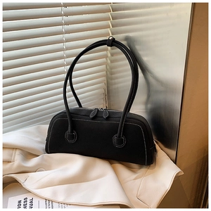 Detail of a black rectangular tote bag with white contrast stitching on a blazer