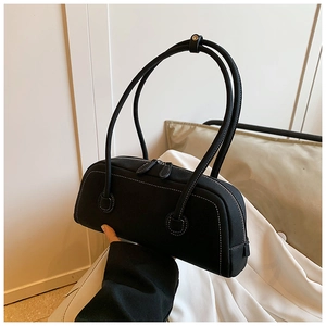 Detail view of the black tote bag featuring contrast white stitching and metal dual zipper