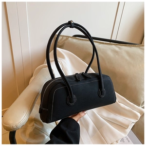 Detail of black tote bag featuring white contrast stitching and dual zipper closures