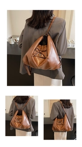 Detail of pleated brown leather bag with bow accent and versatile shoulder straps