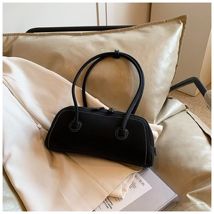 Detail of minimalist black tote bag featuring contrast stitching and leather texture