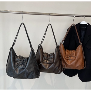 Three vintage Hobo tote bags in charcoal, dark brown and caramel with bow details