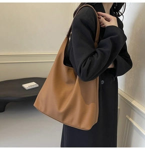 Close-up of a brown large-capacity tote bag with lychee texture and hobo style shoulder strap