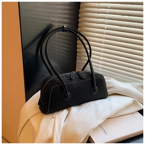 Detail of black tote bag featuring white contrast stitching and dual zipper top closure