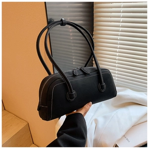 Detail of black tote bag with white contrast stitching and dual zipper closures