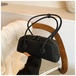 Detail of black tote bag featuring white contrast stitching and dual zipper closure