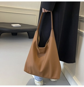 Detailed close-up of brown PU leather texture and soft Hobo design on a large tote bag