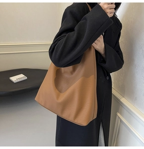 Close-up of caramel brown tote bag with premium lychee texture and long shoulder strap