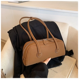 Close-up of brown leather tote bag with white contrast stitching and dual shoulder straps