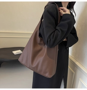 Close-up of the pebbled leather texture and large capacity of the dark brown tote bag