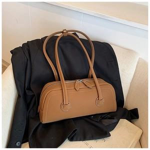 Detail of caramel leather tote bag with white contrast stitching and silver zipper closure