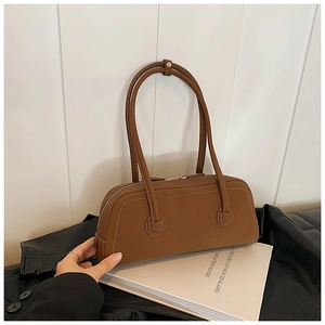 Close-up of brown matte leather tote bag with white contrast stitching detail