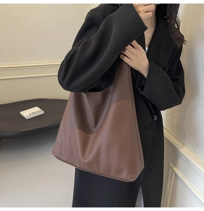 Deep brown large hobo tote bag with lychee texture leather shown on model in minimal setting