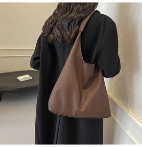 Detail of dark brown pebble leather tote bag showing large capacity and natural texture