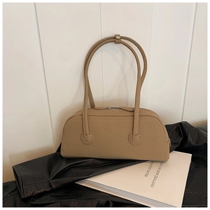 Detail of khaki leather tote bag featuring sleek silver zippers and long shoulder handles