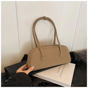 Detail of khaki leather tote bag with white contrast stitching and silver zipper closure