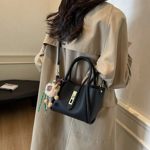 Elegant black lychee leather bucket bag with gold hardware and sheep charm on model