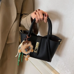 Retro black leather bucket handbag with gold buckle and a cute teddy bear charm