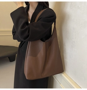 Chic large brown pebbled leather tote bag styled with a professional black blazer suit
