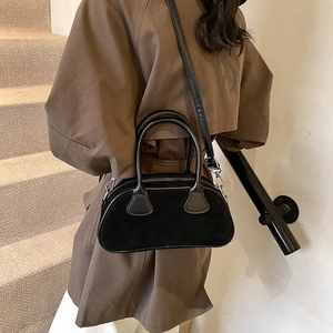 Fashionable black matte bowling shoulder bag for women styled with an autumn trench coat