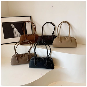 Close-up of minimalist leather tote bags in various earth tones on display stands