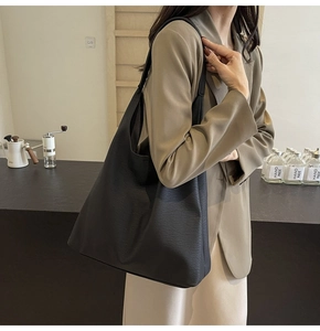 Close-up of black lychee-textured large tote bag on model for modern commute style