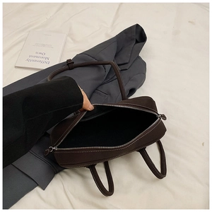 Detail of dark brown tote bag with white contrast stitching and large capacity interior