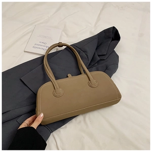 Close-up of khaki matte leather tote bag with elegant top stitching on white fabric