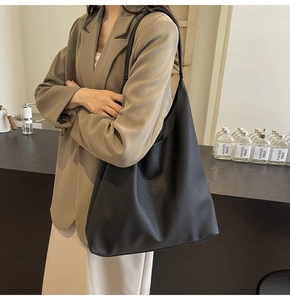 Detail of minimalist black PU leather tote bag with elegant lychee grain texture