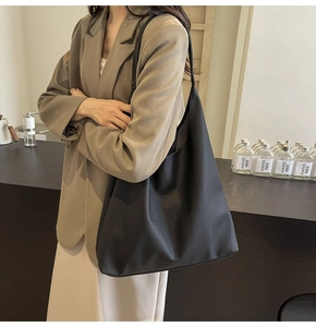 Detail of large black hobo bag in lychee texture leather for daily commute outfits