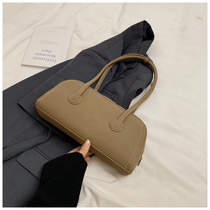 Detail of tan tote bag with white contrast stitching on the edge in a lifestyle scene