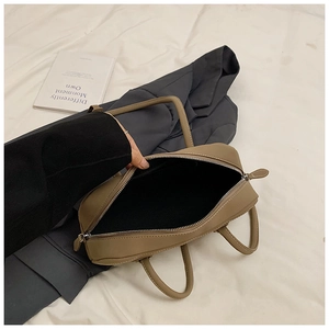 Detailed top view of large dark brown leather tote interior with metal zipper and black lining