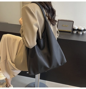 Close-up of black lychee grain leather texture on a large minimalist commuter tote bag