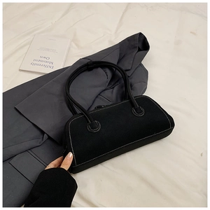 Detail of black tote bag with white contrast stitching and cylindrical handles