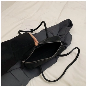 Detail of the black tote bag with white contrast stitching and spacious interior