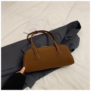 Detail of dark brown tote bag featuring white contrast stitching and slim shoulder straps