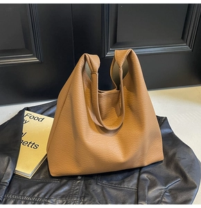 Detailed view of brown lychee texture leather on a large capacity tote bag