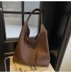 Detail of brown litchi pattern leather tote bag with large capacity and hobo style