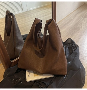 Detail of large brown slouchy tote bag with pebble leather texture for office work
