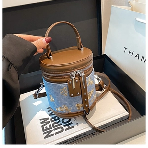 Sac seau cylindrique en denim bleu avec broderies de fleurs et abeilles et cuir marron