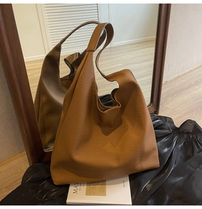 Detail of a brown large capacity hobo bag with high quality lychee texture leather finish