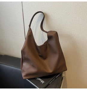 Detailed macro view of the brown lychee-textured leather on this large hobo shoulder bag