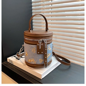 Détail du sac seau en jean vintage avec broderie florale et bandoulière en cuir