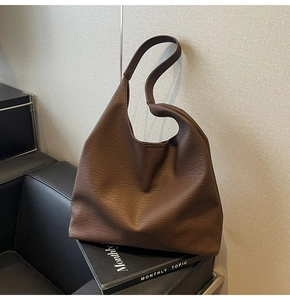 Close-up of the deep brown leather grain texture on this minimalist tote bag