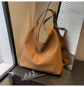 Close-up of brown pebbled leather tote bag showing rich texture and hobo silhouette