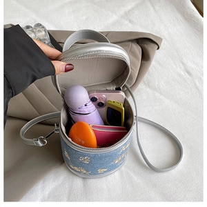 Vue de la capacité du sac seau en denim bleu avec broderies d'or et détails argentés