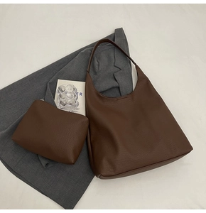 Detail of dark brown tote bag set with pebble grain leather texture and matching pouch
