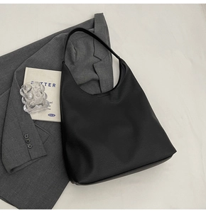 Flat lay of a large black pebbled leather tote bag with a minimalist commuter design