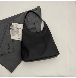 Detailed close-up of high-quality black leather tote bag with smooth texture and soft luster